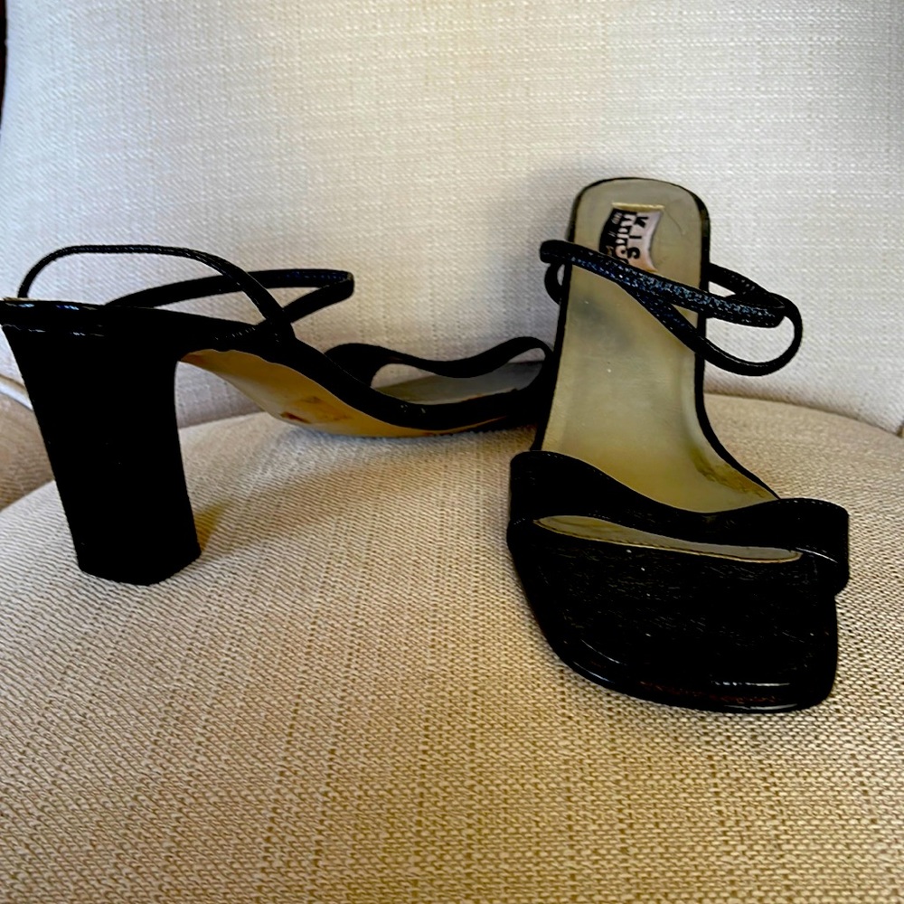 These are black high heels with a black strap.